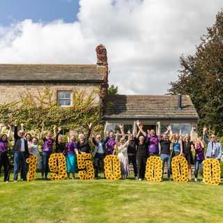 A group of people happy holding up the amount of money raised
