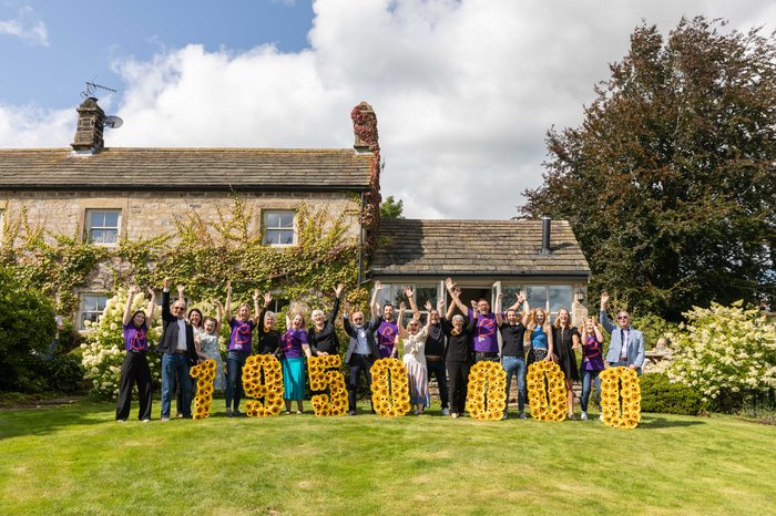 A group of people happy holding up the amount of money raised