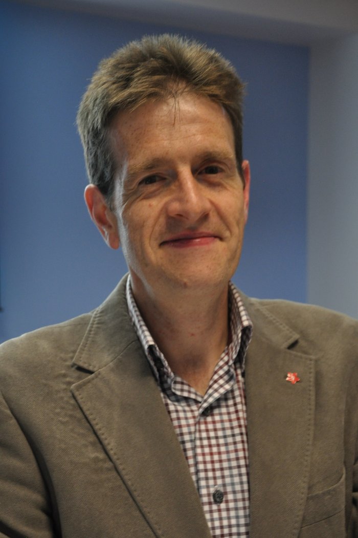 A portrait image of leukemia researcher Anthony Moorman, who is smiling at the camera.