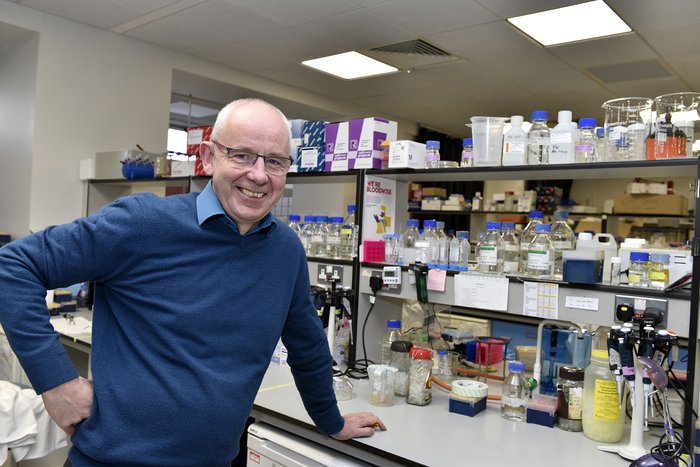 Professor Chris Bunce stood in the lab smiling.