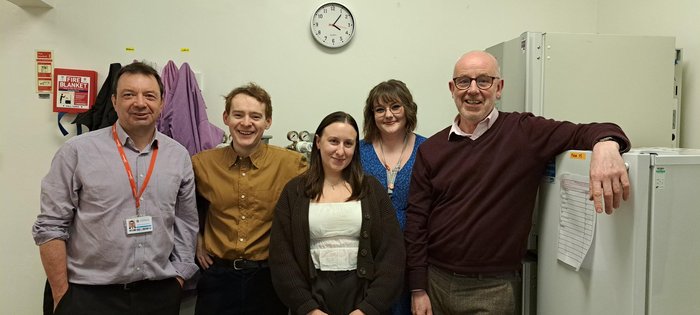 Chris Bunce and the other four members of his research team stood together in the lab.