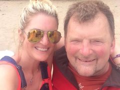 A middle aged couple post together on holiday.