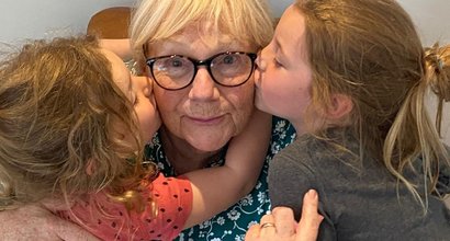 Gail, who's living with essential thrombocythaemia (ET), being hugged by two of her grandchildren.