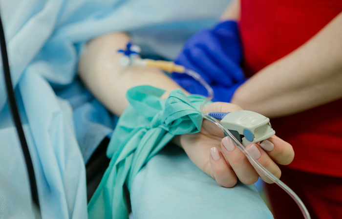 Close up of someone having blood pressure taken via pulse oximeter blood pressure reader.