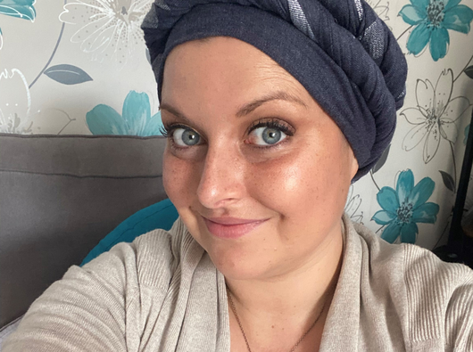 Jemma, a woman in her 30s, takes a selfie against a wall.