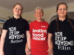 Johanna, holding hands with two female family members in a house.