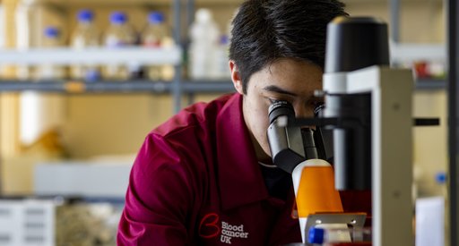Researcher looking into a microscope