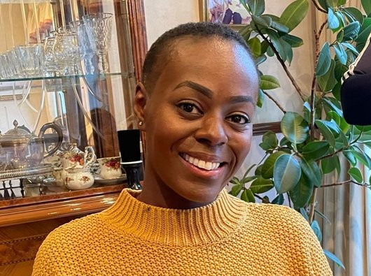 Nadine, wearing a yellow jumper and smiling
