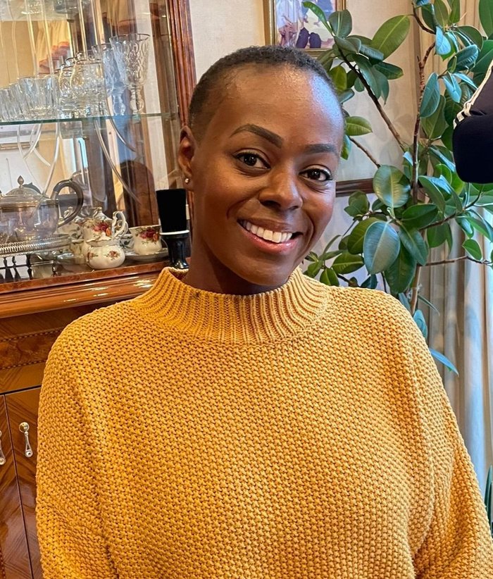 Nadine, wearing a yellow jumper and smiling