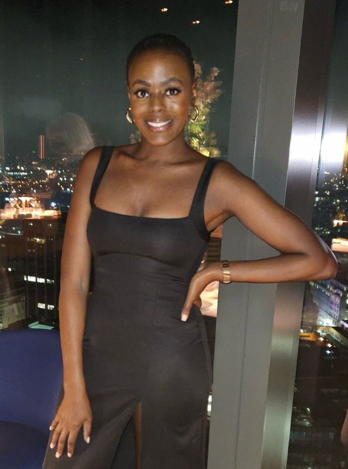 Nadine, standing in a restaurant with her hand on her hip