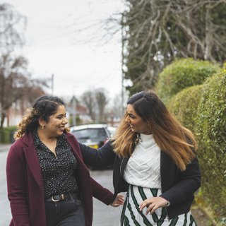 Two friends greeting each other in the street.