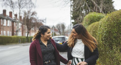 Two friends greeting each other in the street.