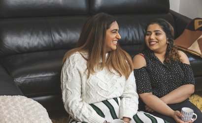 Two friends talking and having a hot drink together.