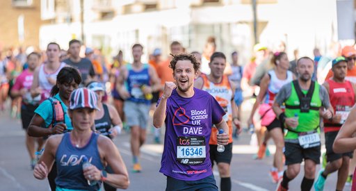 Male Blood Cancer UK runner celebrating with one fist in the air looking towards the camera