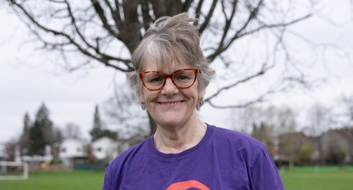Female wearing purple Blood Cancer UK t shirt smiling to the camera