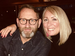Sara, who was diagnosed with Waldenström macroglobulinaemia (WM), with her arm round her husband and smiling.