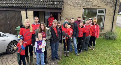 A group of people wearing red Blood Cancer UK branded t-shirts, outside, ready to take on a walk to raise money to beat blood cancer.