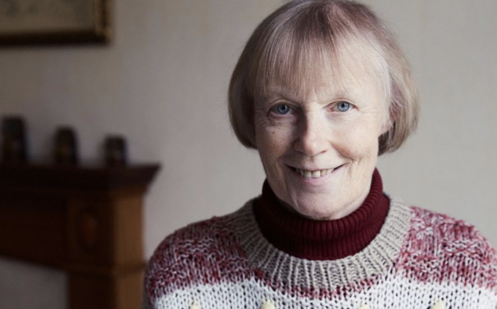 A headshot of Erica, who has chronic lymphocytic leukaemia (CLL), wearing a thick knitted jumper smiling into the camera.