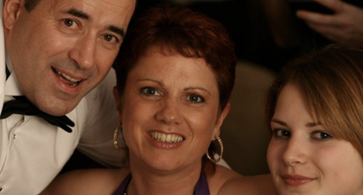A close-up of Donna, who was diagnosed with follicular lymphoma, smiling with family at a formal event.