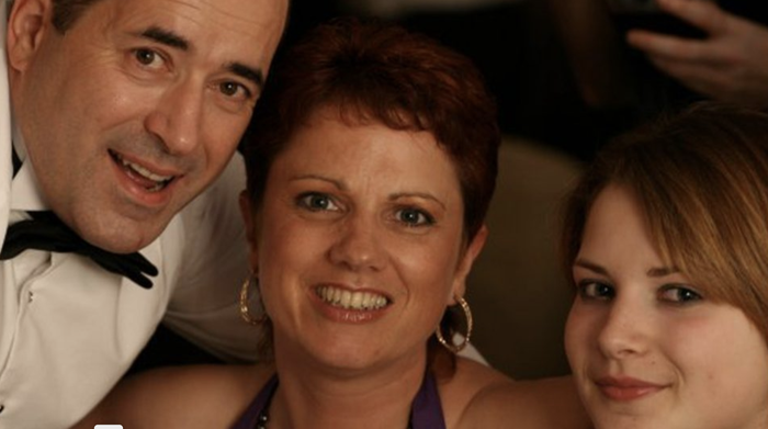 A close-up of Donna, who was diagnosed with follicular lymphoma, smiling with family at a formal event.