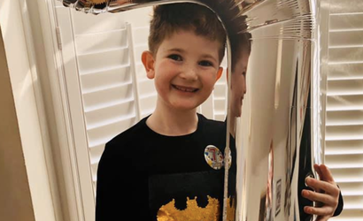 Hugo, who was diagnosed with childhood acute lymphoblastic leukaemia, posing at home with a large helium balloon.