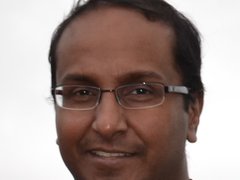 A man, wearing glasses, in a head shot.