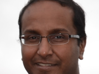 A man wearing glasses in a headshot.