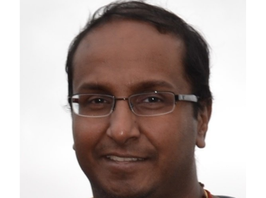 A man, wearing glasses, in a head shot.