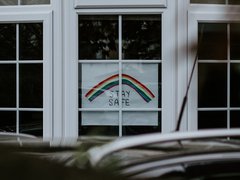 Window with a handmade poster displaying a rainbow with the words 'Stay safe' underneath.