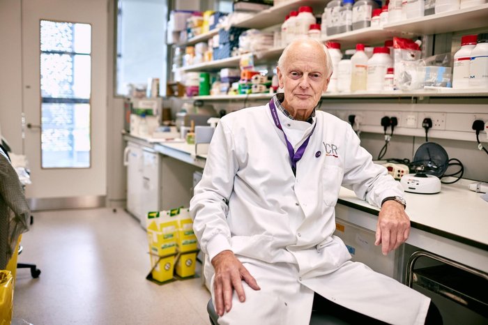 Professor Terry Rabbitts sitting in the lab wearing his lab coat