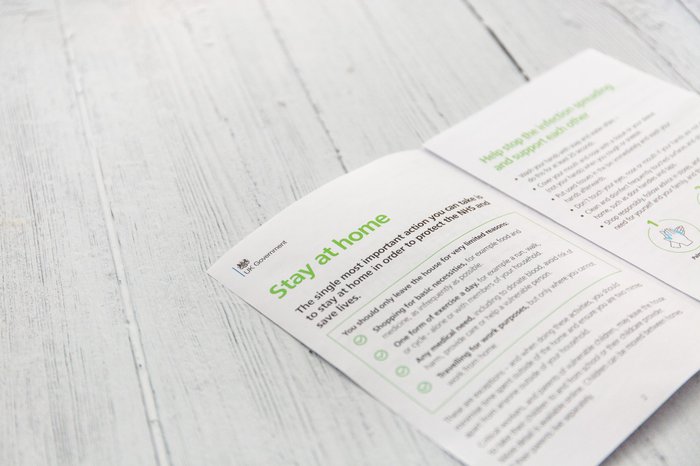 A stock image of an open page of a Government leaflet with advice about staying at home.