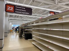 A stock image of a canned goods aisle in a supermarket, completely empty.