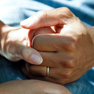 A close up of two people holding hands
