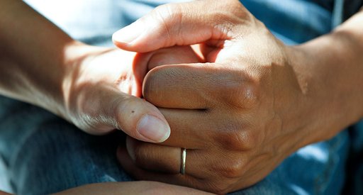 A close up of two people holding hands