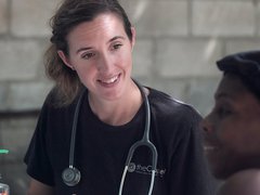 Doctor with stethoscope round neck talking to female patient about treatment.