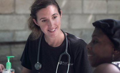Doctor with stethoscope round neck talking to female patient about treatment.